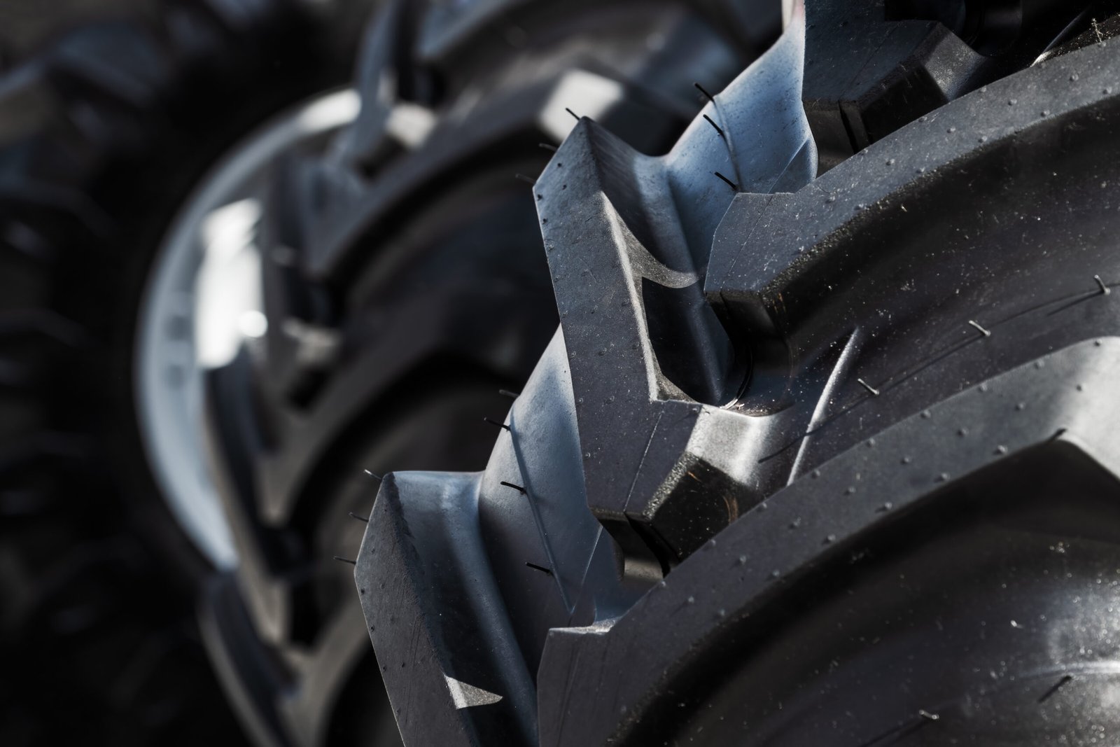 Brand new unused tractor tire with with lug tread, selective focus